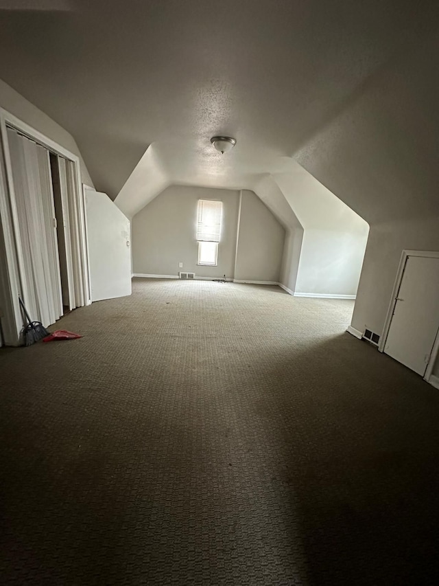 additional living space featuring lofted ceiling and carpet floors