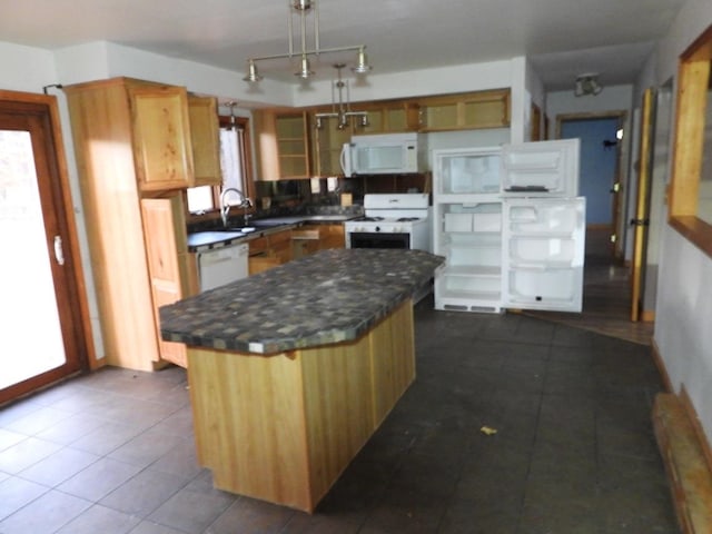 kitchen featuring pendant lighting, a center island, white appliances, sink, and dark tile patterned floors