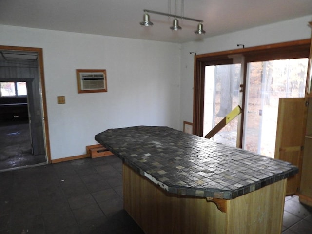 kitchen featuring tile countertops, decorative light fixtures, a healthy amount of sunlight, and a wall mounted air conditioner