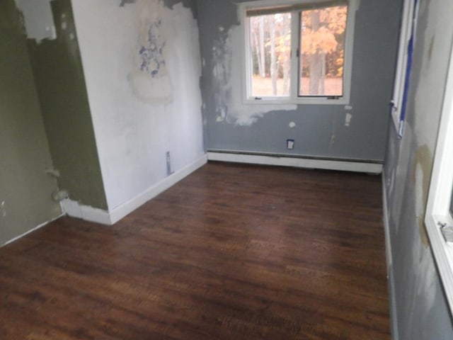 unfurnished room with dark hardwood / wood-style flooring and baseboard heating