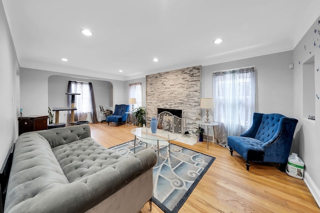 living room with light hardwood / wood-style flooring and a stone fireplace