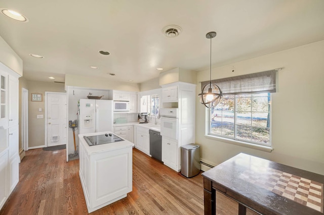 kitchen with white cabinets, a center island, white appliances, and a wealth of natural light