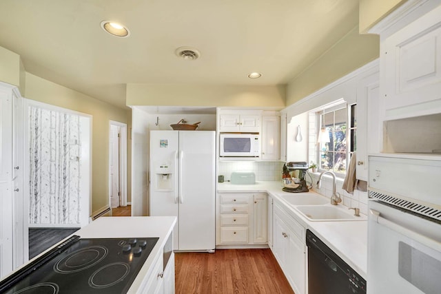 kitchen with sink, backsplash, hardwood / wood-style floors, white cabinets, and black appliances