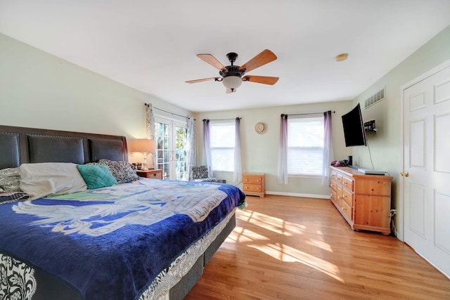 bedroom featuring ceiling fan, light hardwood / wood-style floors, and french doors