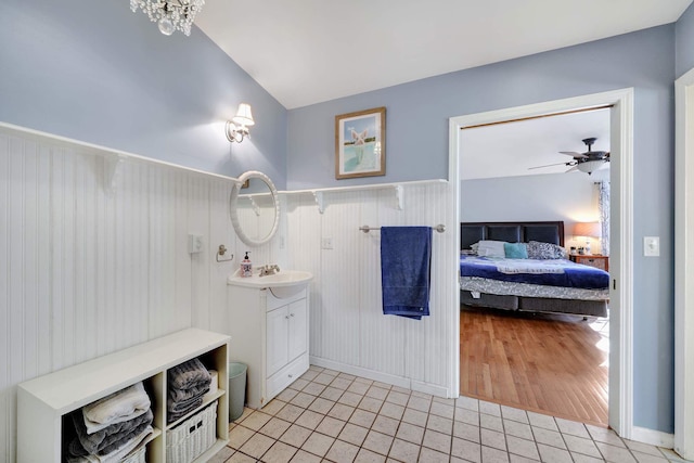 bathroom featuring vanity, hardwood / wood-style floors, ceiling fan with notable chandelier, and vaulted ceiling