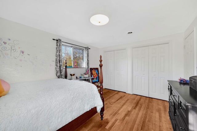 bedroom with hardwood / wood-style flooring and multiple closets