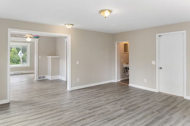 empty room featuring ceiling fan and light hardwood / wood-style floors