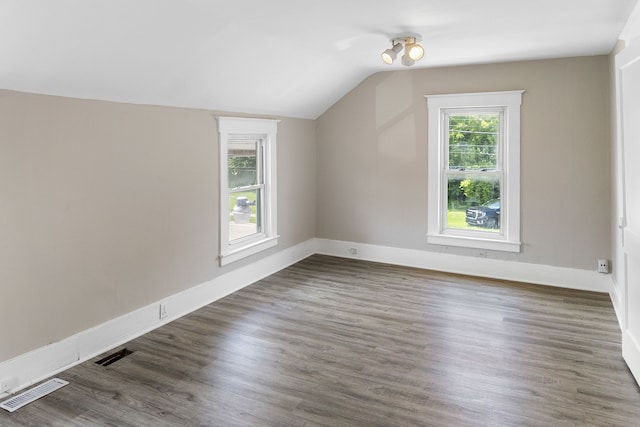 additional living space featuring lofted ceiling and dark hardwood / wood-style floors