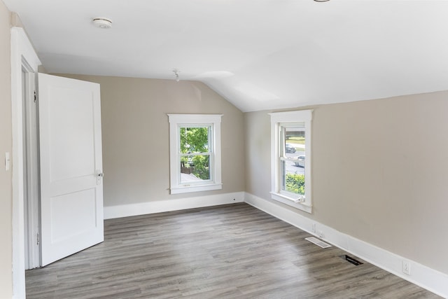 bonus room with vaulted ceiling and light wood-type flooring