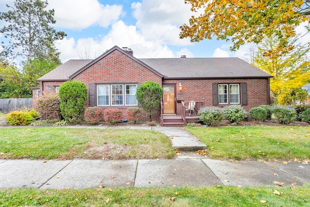 bungalow with a wooden deck and a front yard