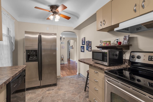 kitchen with hardwood / wood-style flooring, ceiling fan, dark stone countertops, cream cabinetry, and stainless steel appliances