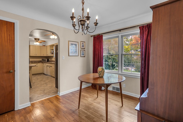 dining area with ceiling fan with notable chandelier and light wood-type flooring