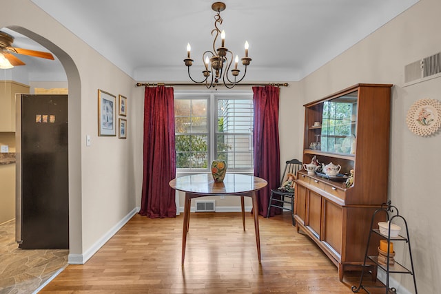 dining area featuring ceiling fan with notable chandelier and light hardwood / wood-style flooring