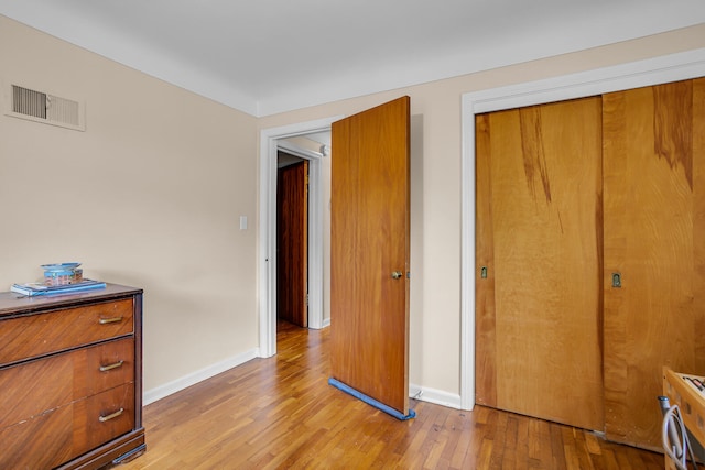 unfurnished bedroom with a closet and light hardwood / wood-style floors