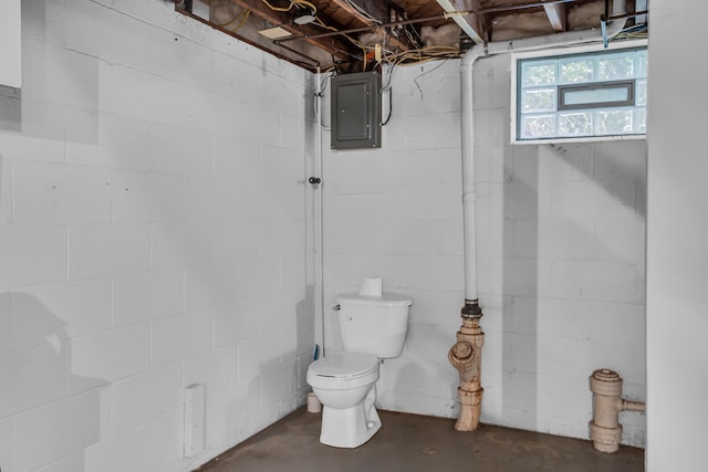 bathroom with concrete floors, electric panel, and toilet