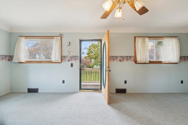 foyer entrance featuring carpet, ceiling fan, and a healthy amount of sunlight