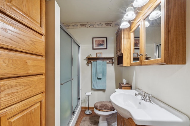 bathroom with vanity, toilet, and a shower with door