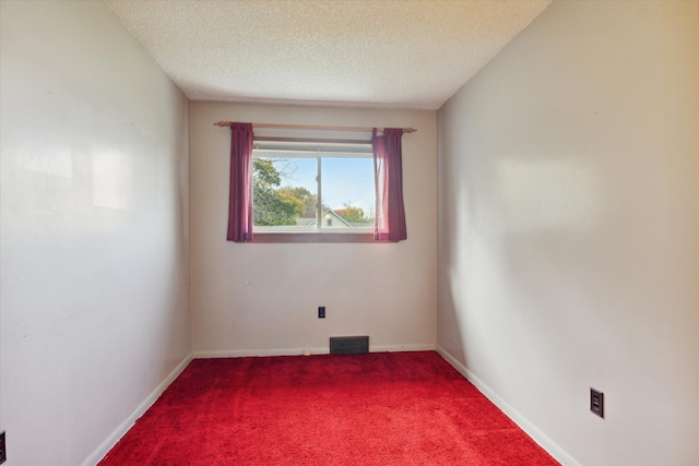 unfurnished room with carpet floors and a textured ceiling