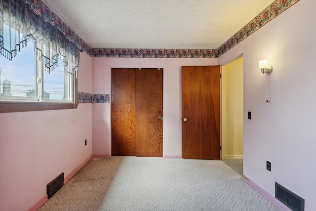 unfurnished bedroom featuring carpet floors and a textured ceiling