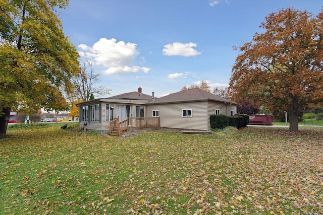 back of property featuring a lawn and a deck