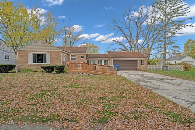 ranch-style house featuring a garage, a wooden deck, and a front lawn