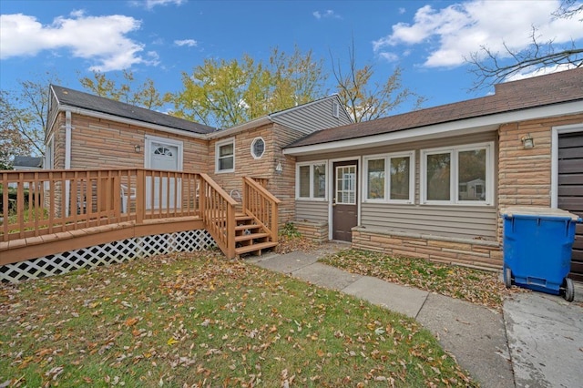 view of front facade with a deck and a front yard