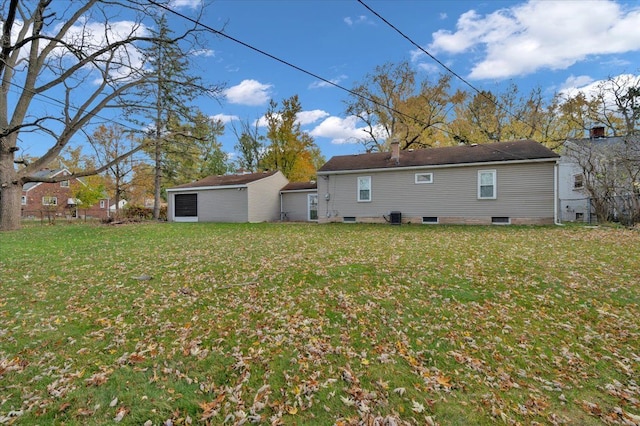 rear view of house featuring central AC and a lawn