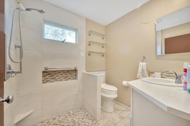 bathroom featuring vanity, toilet, and tiled shower