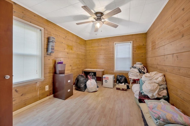 interior space featuring wood walls, ceiling fan, and light wood-type flooring