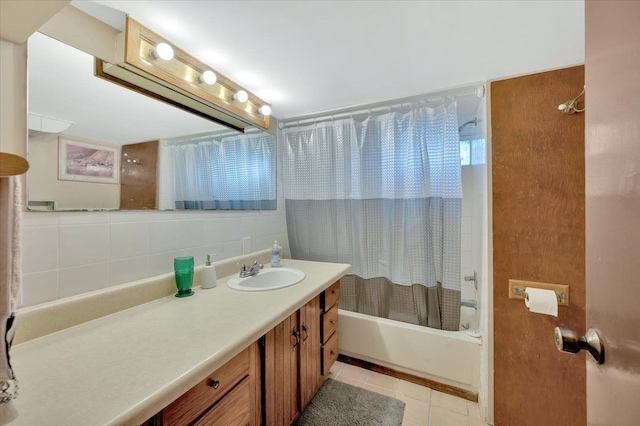 bathroom with tile patterned flooring, backsplash, shower / bath combo with shower curtain, vanity, and tile walls