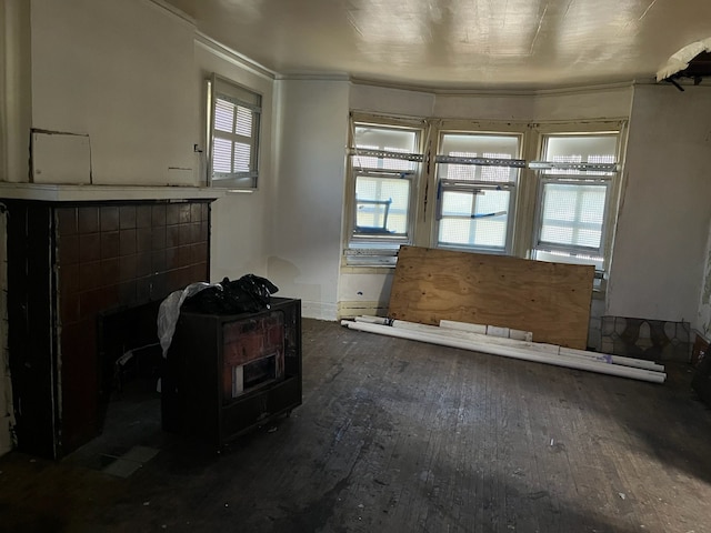 unfurnished living room featuring a fireplace, ornamental molding, and wood-type flooring