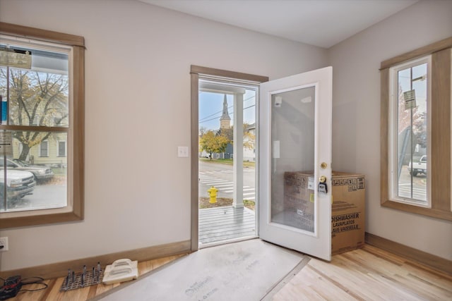 doorway to outside featuring plenty of natural light, light hardwood / wood-style floors, and french doors