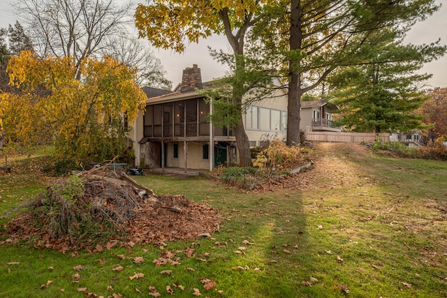 back of property with a sunroom and a yard