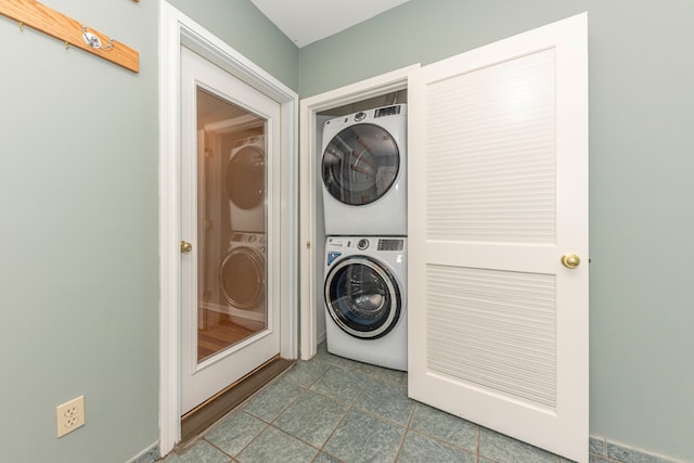 washroom featuring tile patterned floors and stacked washer / drying machine