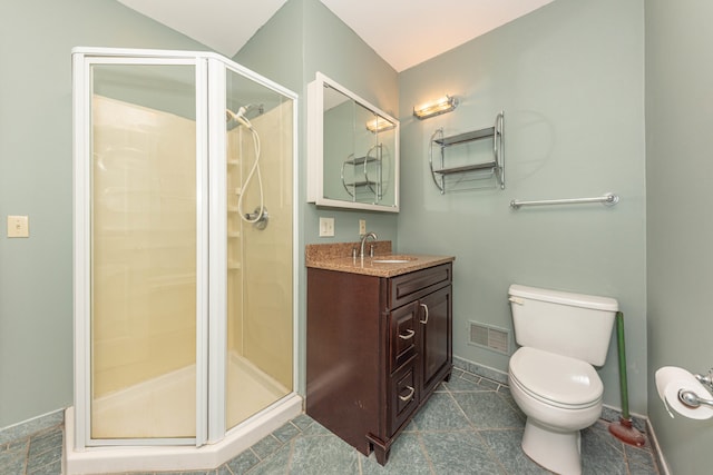 bathroom featuring tile patterned floors, vanity, toilet, and an enclosed shower