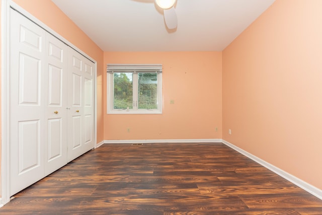 unfurnished bedroom with ceiling fan, dark wood-type flooring, and a closet