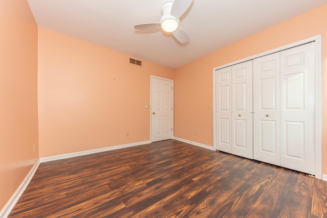 unfurnished bedroom featuring ceiling fan, dark hardwood / wood-style floors, and a closet