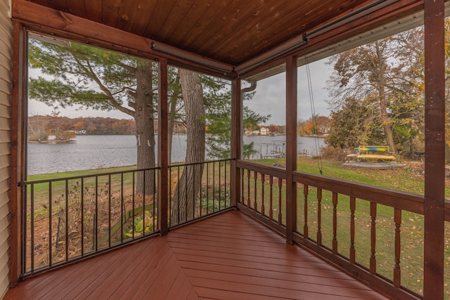 unfurnished sunroom featuring a water view and wooden ceiling