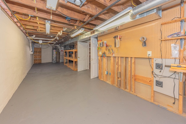 basement with a workshop area and water heater