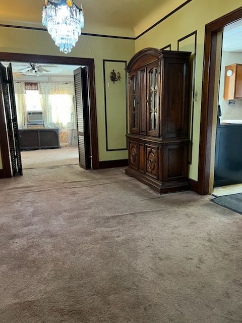 interior space featuring light colored carpet and a notable chandelier