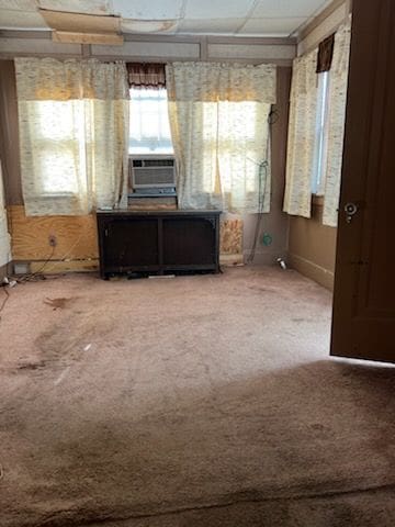 interior space featuring carpet flooring, a paneled ceiling, and cooling unit