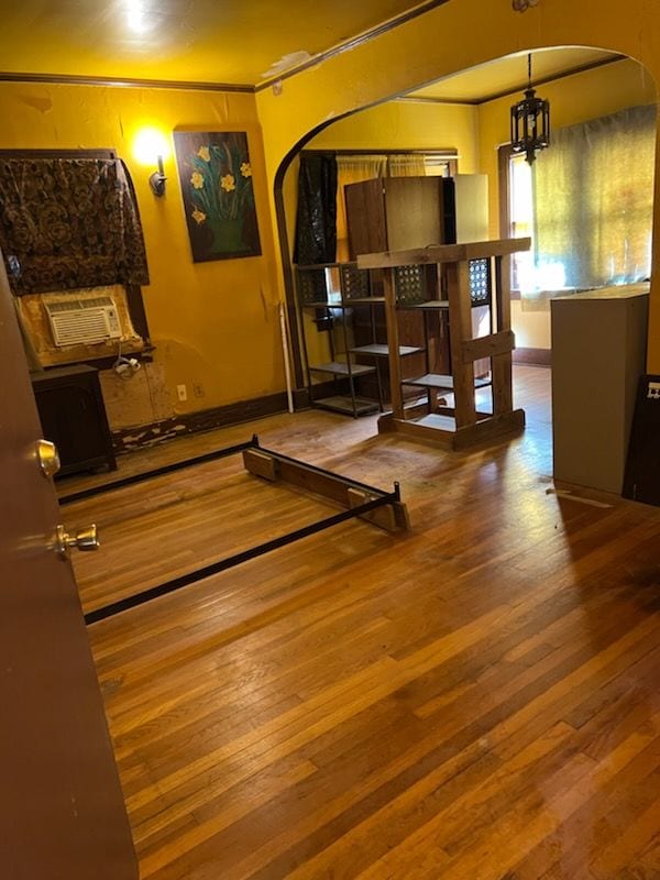 workout area with hardwood / wood-style floors, cooling unit, and a chandelier