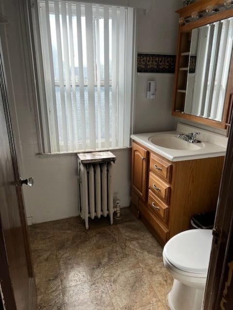 bathroom featuring radiator, vanity, and toilet