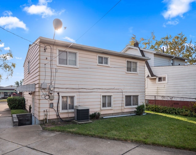 back of house with a yard and central AC