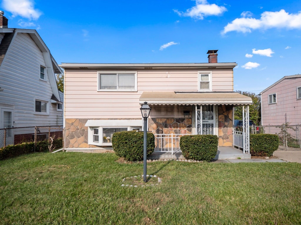 rear view of property featuring a yard