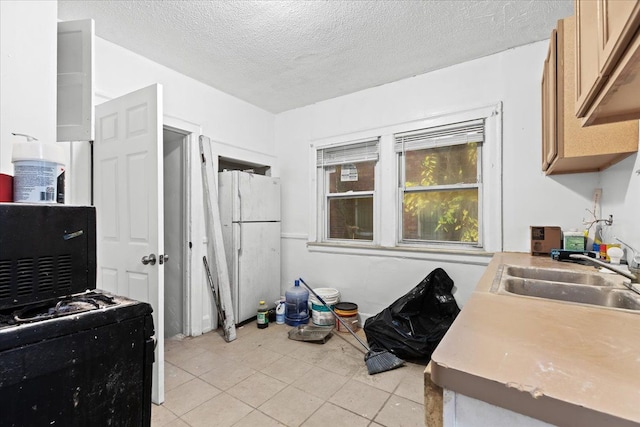 16644 Washburn St, Detroit, MI 48221 - kitchen featuring a sink, freestanding refrigerator, a textured ceiling, light tile patterned flooring, and light countertops