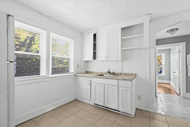 16644 Washburn St, Detroit, MI 48221 - kitchen with open shelves, a sink, white cabinetry, light tile patterned flooring, and baseboards