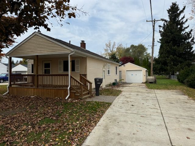 bungalow with a garage, covered porch, and an outdoor structure