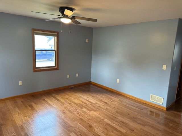 unfurnished room with light wood-type flooring and ceiling fan