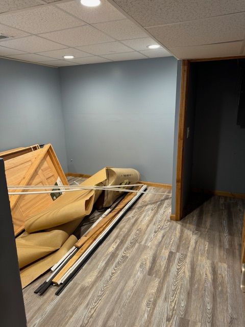 miscellaneous room featuring a drop ceiling and hardwood / wood-style flooring